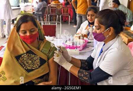 Beawar, Rajasthan, Inde, 27 juin 2021 : un jeune bénéficiaire réagit lorsqu'elle reçoit une dose de Covishield (vaccin COVID-19) lors d'une campagne de vaccination spéciale dans un centre de vaccination de Beawar. Le premier cas de la variante Delta-plus du coronavirus dans le Rajasthan a été trouvé dans le Bikaner. Au total, 48 cas de Delta plus et quatre décès ont été signalés dans 10 États de l'Inde. Crédit : Sumit Saraswat/Alay Live News Banque D'Images