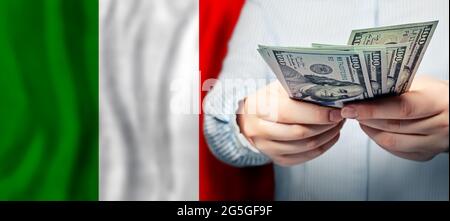 Des couleurs vives agitant le drapeau national italien et l'argent du dollar américain entre les mains. Économie du pays, financier. Italie concept de finance Banque D'Images