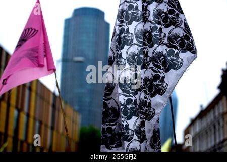 Londres, Royaume-Uni. 27 juin 2021. Un grand drapeau du crâne est porté par un activiste lors de la manifestation Free the Press à Londres. Après avoir soulevé l'alarme sur la presse milliardaire corrompue qui profite de notre division et ne parvient toujours pas à dire la vérité sur le climat et la crise écologique, extinction rébellion a lancé un débat national dans le processus autour de la nécessité de LIBÉRER LA VÉRITÉ. Ils se sont joints à un débat avec le Daily Telegraph pour commencer. Crédit : SOPA Images Limited/Alamy Live News Banque D'Images