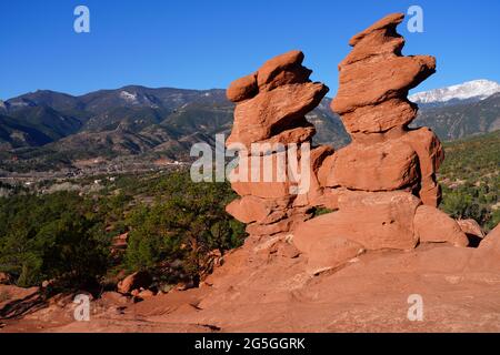 Vue sur le pic de Pikes à travers le trou dans la formation de roches rouges Siamese Twins dans le parc Garden of the Gods à Colorado Springs, Colorado, États-Unis Banque D'Images