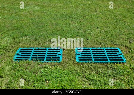 le drainage de trou d'homme râpe sur la pelouse avec l'herbe verte, le couvercle de fosse septique, le puisard cesspool système de drainage environnement conception avec l'espace de copie, personne. Banque D'Images