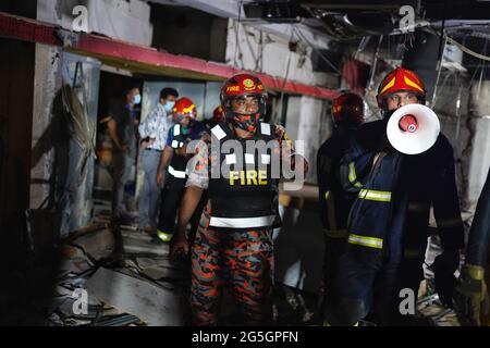 Dhaka, Bangladesh. 27 juin 2021. Les pompiers inspectent la scène après une explosion de gaz présumée dans la région de Moghbazar à Dhaka.au moins sept personnes ont été tuées et 50 ont été blessées jusqu'à ce que le bâtiment de trois étages dans la région de Moghbazar dans la capitale du Bangladesh, Dhaka, s'est partiellement effondré dans une explosion de gaz présumée. Crédit : SOPA Images Limited/Alamy Live News Banque D'Images