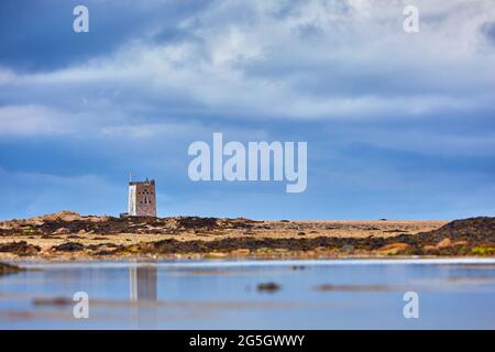 Image de la tour Seymour avec ciel nuageux et réflexion dans la piscine avec des ondulations. Jersey, îles Anglo-Normandes. Mise au point sélective Banque D'Images