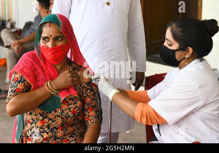 Un agent de santé administre une dose de Covishield (vaccin COVID-19) à une femme rurale lors d'une campagne de vaccination spéciale dans un centre de vaccination de Beawar. Le premier cas de la variante Delta-plus du coronavirus dans le Rajasthan a été trouvé dans le Bikaner. L'échantillon d'une femme qui a été testée positive pour le coronavirus a été envoyé à l'Institut national de virologie de Pune le 30 mai pour le séquençage du génome et son rapport d'essai a eu lieu le 25 juin. Au total, 48 cas de Delta plus et quatre décès ont été signalés dans 10 États de l'Inde. (Photo de Sumit Saraswat/Pacific Press) Banque D'Images