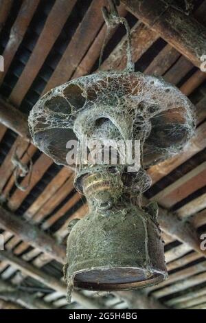 vieille lampe à kérosène accrochée au plafond d'une maison rurale couverte de toile d'araignées Banque D'Images