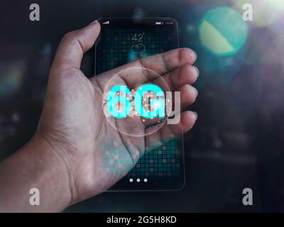Concept futuriste moderne de technologie de téléphone en verre transparent. Réseau Internet mobile haut débit 6G sur le futur smartphone fin transparent à portée de main Banque D'Images
