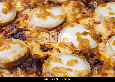 Gros plan de pizza garnie de fromage de chèvre et d'oignon caramélisé. Photo macro de produits délicieux. Banque D'Images