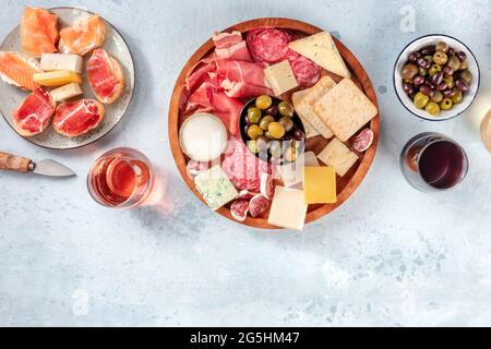 Buffet avec vin et hors-d'œuvre. Épicerie fine italienne. Un plateau de collations avec du saumon, du prosciutto, du jamon, des olives et du fromage. Photo de la nourriture et des boissons en hauteur Banque D'Images