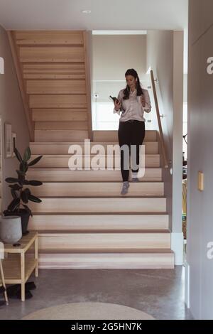 Femme d'affaires qui se trouve au rez-de-chaussée et qui travaille au bureau à domicile Banque D'Images