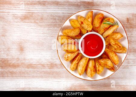 Quartiers de pommes de terre cuits avec espace de copie, photographiés d'en haut sur un fond rustique Banque D'Images