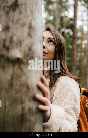 Jeune femme regardant l'arbre dans la forêt Banque D'Images