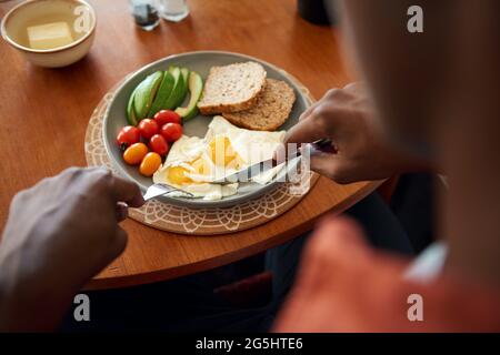 Jeune homme africain prenant un petit déjeuner maison Banque D'Images