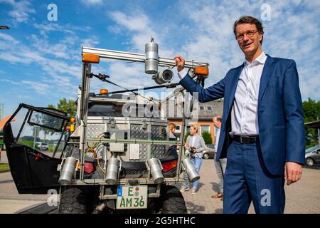 Beckum, Allemagne. 28 juin 2021. Hendrik Wüst (CDU), ministre des Transports de l'État de Rhénanie-du-Nord-Westphalie, se tient par un buggy spécial équipé de caméras et de lampes laser lors de la présentation du projet de Straßen NRW d'enregistrer et d'évaluer le réseau de pistes cyclable. A partir de la fin juin, le véhicule à quatre voies sera sur la route des chemins cyclables le long des routes fédérales et nationales dans la région de Münsterland, et plus tard le buggy sera également vu dans d'autres parties de l'État. Un résultat devrait être disponible en 2022. Credit: Guido Kirchner/dpa/Alay Live News Banque D'Images