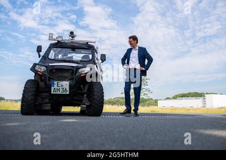 Beckum, Allemagne. 28 juin 2021. Hendrik Wüst (CDU), ministre des Transports de l'État de Rhénanie-du-Nord-Westphalie, se tient par un buggy spécial équipé de caméras et de lampes laser lors de la présentation du projet de Straßen NRW d'enregistrer et d'évaluer le réseau de pistes cyclable. A partir de la fin juin, le véhicule à quatre voies sera sur la route des chemins cyclables le long des routes fédérales et nationales dans la région de Münsterland, et plus tard le buggy sera également vu dans d'autres parties de l'État. Un résultat devrait être disponible en 2022. Credit: Guido Kirchner/dpa/Alay Live News Banque D'Images