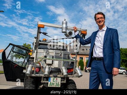 Beckum, Allemagne. 28 juin 2021. Hendrik Wüst (CDU), ministre des Transports de l'État de Rhénanie-du-Nord-Westphalie, se tient par un buggy spécial équipé de caméras et de lampes laser lors de la présentation du projet de Straßen NRW d'enregistrer et d'évaluer le réseau de pistes cyclable. A partir de la fin juin, le véhicule à quatre voies sera sur la route des chemins cyclables le long des routes fédérales et nationales dans la région de Münsterland, et plus tard le buggy sera également vu dans d'autres parties de l'État. Un résultat devrait être disponible en 2022. Credit: Guido Kirchner/dpa/Alay Live News Banque D'Images