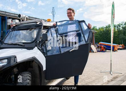 Beckum, Allemagne. 28 juin 2021. Hendrik Wüst (CDU), ministre des Transports de l'État de Rhénanie-du-Nord-Westphalie, se tient par un buggy spécial équipé de caméras et de lampes laser lors de la présentation du projet de Straßen NRW d'enregistrer et d'évaluer le réseau de pistes cyclable. A partir de la fin juin, le véhicule à quatre voies sera sur la route des chemins cyclables le long des routes fédérales et nationales dans la région de Münsterland, et plus tard le buggy sera également vu dans d'autres parties de l'État. Un résultat devrait être disponible en 2022. Credit: Guido Kirchner/dpa/Alay Live News Banque D'Images