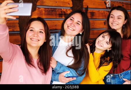 Un groupe de filles heureuses prenant un selfie - quatre amies heureuses prenant des photos d'elles-mêmes au téléphone - filles amies s'amusant avec le téléphone, Banque D'Images