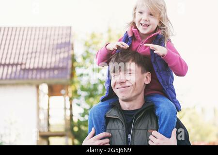 Papa et fille s'amusent ensemble - un papa seul joue avec sa fille et la tient sur ses épaules - heureux parent-enfant concept de relation Banque D'Images