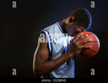 Joueur de basket-ball concentré avec ballon en studio Banque D'Images