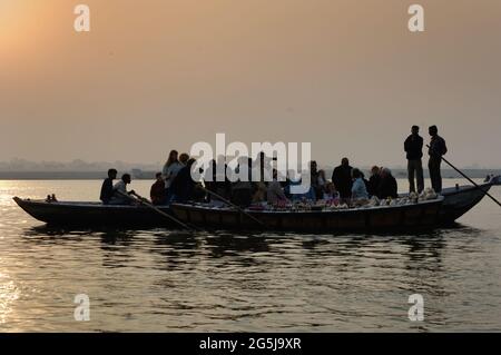 Bateaux tôt le matin et à l'aube de touristes et de vendeurs de souvenirs sur le Gange à Varanasi, Uttar Pradesh, Inde Banque D'Images