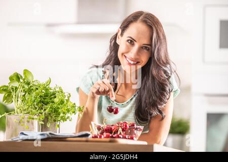 Récolte d'été fraîche de cerises apporté à l'intérieur par une femme belle-apparence dans un bol de seethrough. Banque D'Images