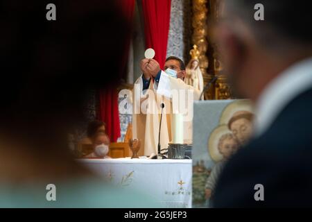 Prêtre catholique portant un masque facial tout en célébrant la messe pendant la pandémie COVID-19 Banque D'Images