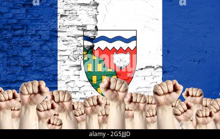 Fists élevés d'hommes sur le fond du drapeau des Territoires du Nord-Ouest peint sur le mur, le concept de l'unité populaire et l'opinion de t Banque D'Images