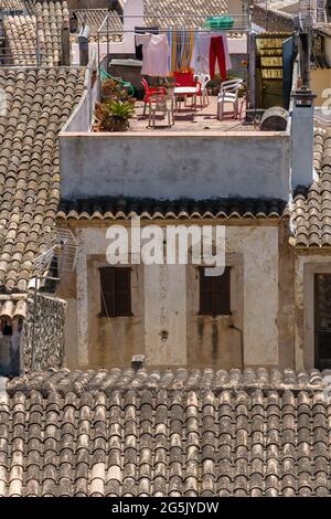 Sécher des vêtements sur une corde à linge à l'extérieur. Maisons au toit en tuiles traditionnelles dans la belle vieille ville d'Arta, Majorque, Espagne. Culture méditerranéenne. Banque D'Images