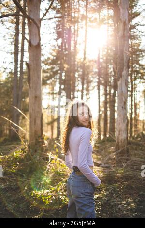 Jeune fille brune marchant dans la forêt Banque D'Images