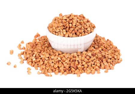 Grains de sarrasin rôtis dans un bol, isolés sur fond blanc. Gruaux de sarrasin brun sec. Banque D'Images