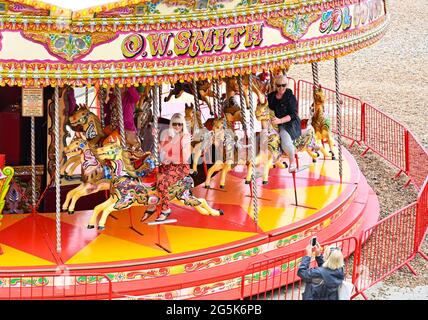 Brighton Royaume-Uni 28 juin 2021 - temps de profiter d'une promenade sur le carrousel de bord de mer de Brighton dans un après-midi chaud mais brumeux le long de la côte sud : crédit Simon Dack / Alamy Live News Banque D'Images