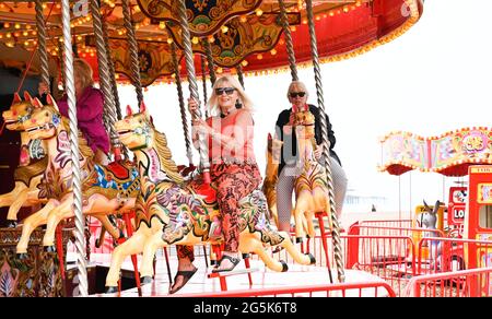 Brighton Royaume-Uni 28 juin 2021 - temps de profiter d'une promenade sur le carrousel de bord de mer de Brighton dans un après-midi chaud mais brumeux le long de la côte sud : crédit Simon Dack / Alamy Live News Banque D'Images