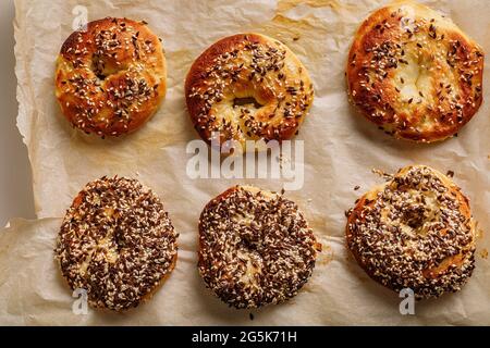 Bagels frais et croustillants aux graines de sésame et de lin. La meilleure recette de Bagel maison de style New-yorkais. Petits pains savoureux au sésame croustillant. Cuisson maison. Chaud Banque D'Images