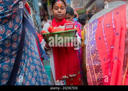 Kolkata, Bengale-Occidental, Inde - 15 avril 2019 : jeune femme mariée hindoue transportant du matériel de culte dans un seau et marchant parmi les dévotés . Image Banque D'Images