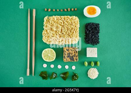 Flat Lay concept ramen ingrédients soupe nouilles, oeuf, algues wakame sur le vert Banque D'Images