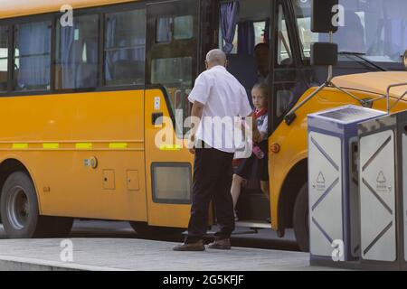 Huzhou, Chine 22 juin 2021: Bonne fille caucasienne de retour à l'école en uniforme et cravate rouge chez Pioneer. Un enfant attend un bus public à la gare Banque D'Images