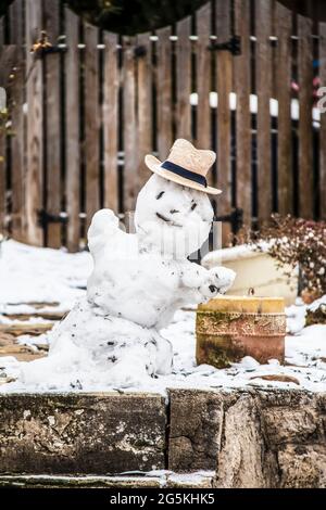 Petit bonhomme de neige dans un chapeau de paille devant une clôture en bois - foyer sélectif Banque D'Images