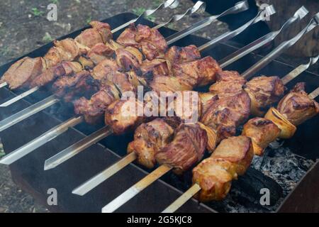 Brochettes de porc accroché à une brochette de métal et faire frire sur le gril Banque D'Images