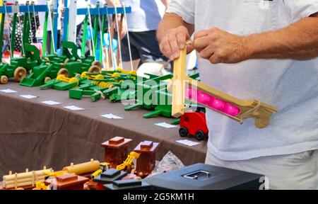 Toymakers met les mains d'un jouet en bois dans un stand à l'extérieur du festival Banque D'Images