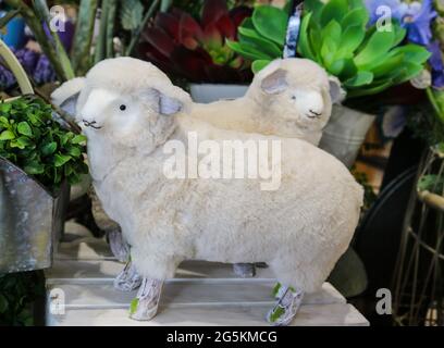 Deux adorables tissus décoratifs et agneaux à ressort en fourrure devant les plantes - attention sélective Banque D'Images