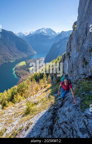 Vue panoramique sur la Königssee depuis le Rinnkendlsteig, jeune femme qui fait de la randonnée jusqu'à l'Achenkanzel, forêt automnale et montagnes enneigées, Berchtesga Banque D'Images