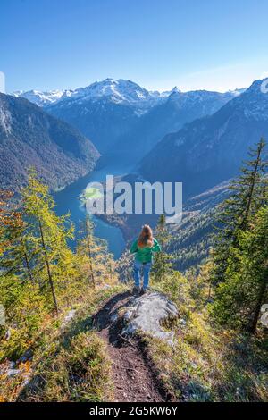 Vue panoramique sur le Königssee, jeune randonneur sur l'Achenkanzel, forêt automnale et montagnes enneigées, parc national de Berchtesgaden, Berchtesgade Banque D'Images