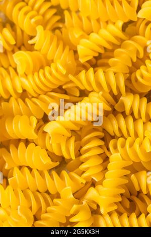 Faites sécher les pâtes à la rotini biologique jaune dans un bol Banque D'Images