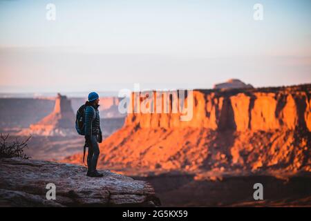 Une randonneur femelle donne sur le parc national de Canyonlands au coucher du soleil, Utah Banque D'Images