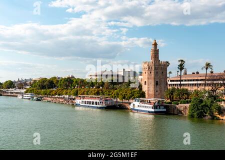 Vue sur le fleuve Rio Guadalquivir sur la promenade avec des bateaux d'excursion et Torre del Oro, Séville, Andalousie, Espagne, Europe Banque D'Images