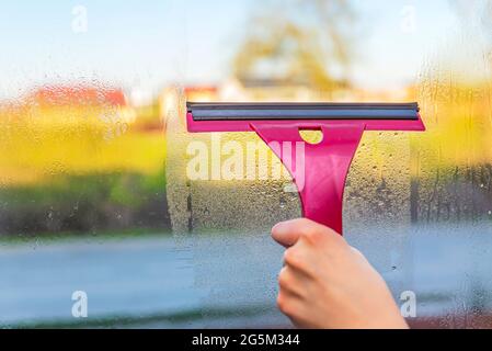 Gouttes de condensation sur la fenêtre. Femme élimine la condensation des vitres. Saison froide. Différence de température. Banque D'Images