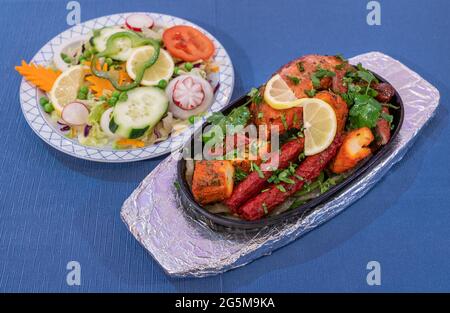 Mélanger la viande grillée avec de la sauce au poivre et des légumes sur fond bleu. Cuisine traditionnelle indienne. Banque D'Images