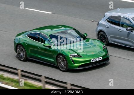 2021 nouvelle Porsche 4S verte 1 vitesse de conduite automatique de l'électricité sur l'autoroute M6 près de Preston à Lancashire, Royaume-Uni. Banque D'Images