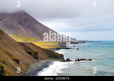 Iceland mountains paysage vue du périphérique, falaise rocheuse brune le jour nuageux dans l'est sud-est avec l'eau de l'océan Atlantique Banque D'Images