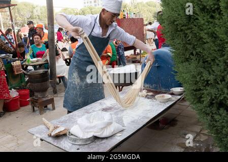 Tirer et plier un brin de pâte sur le marché de Holan Banque D'Images